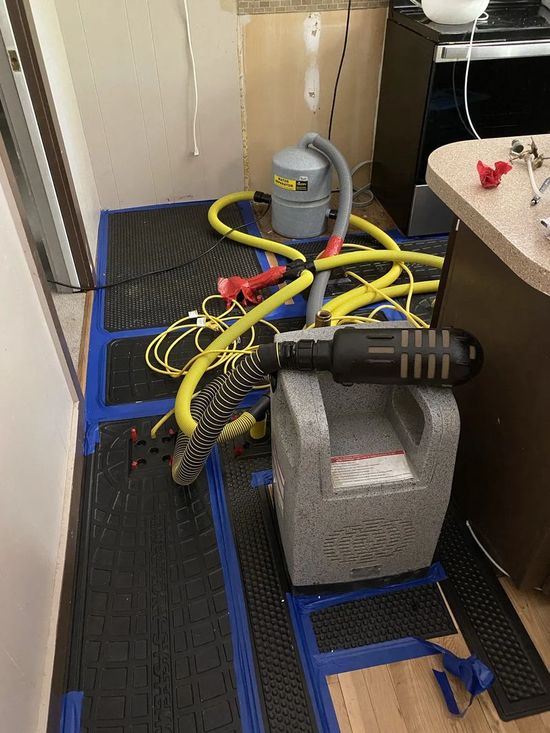 Moisture meter reading showing elevated moisture content on a subfloor after a water loss