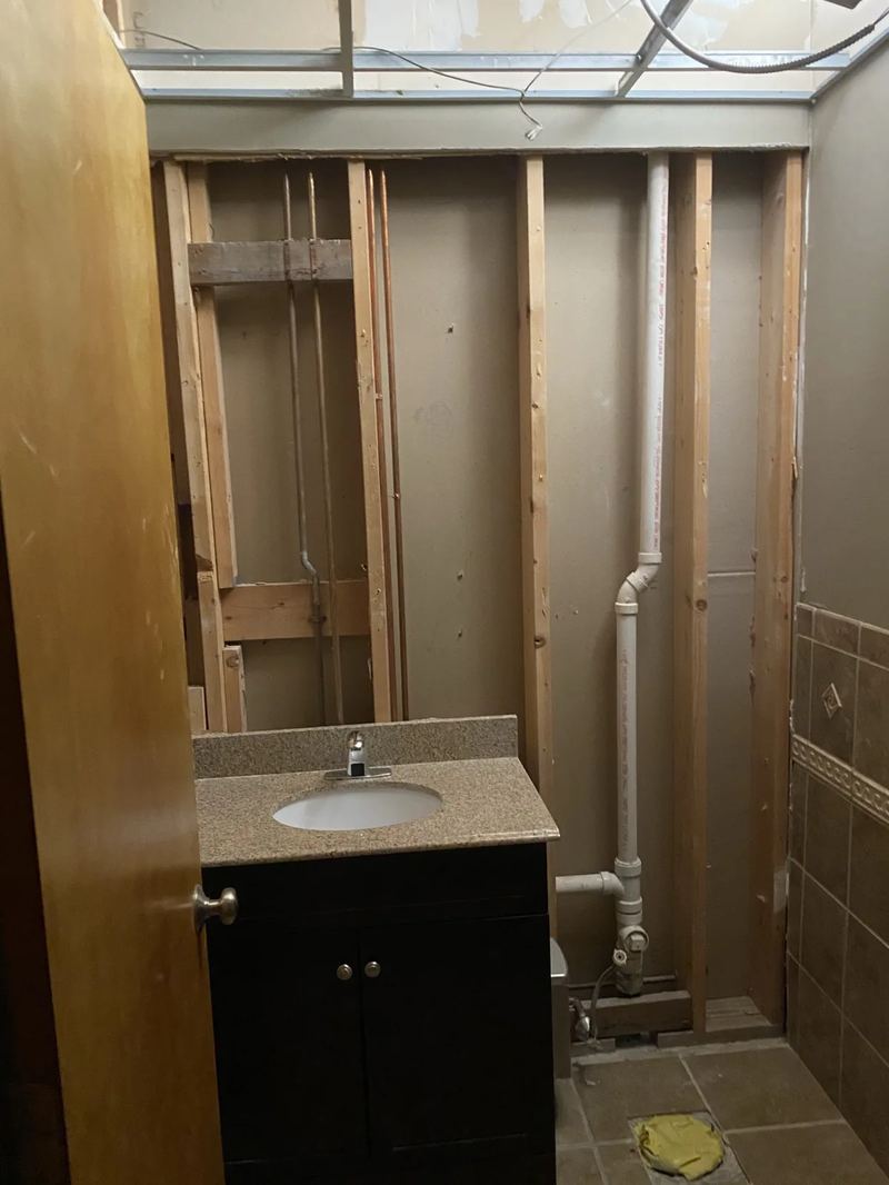 Hammer probe locating hidden water damage beneath layered subflooring